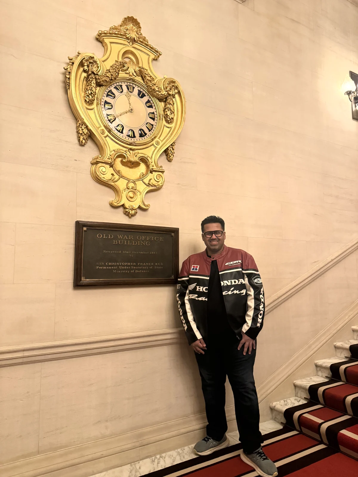 Aadil beneath the gilded clock on the staircase landing