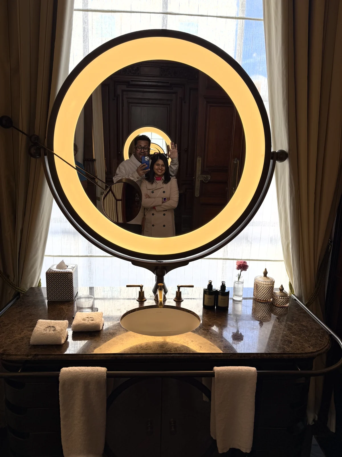 Illuminated round mirror above the vanity in the Granville Suite bathroom